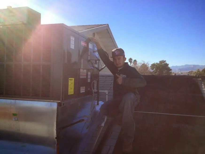 HVAC technician performing Air Duct Repair on a rooftop unit in Columbus